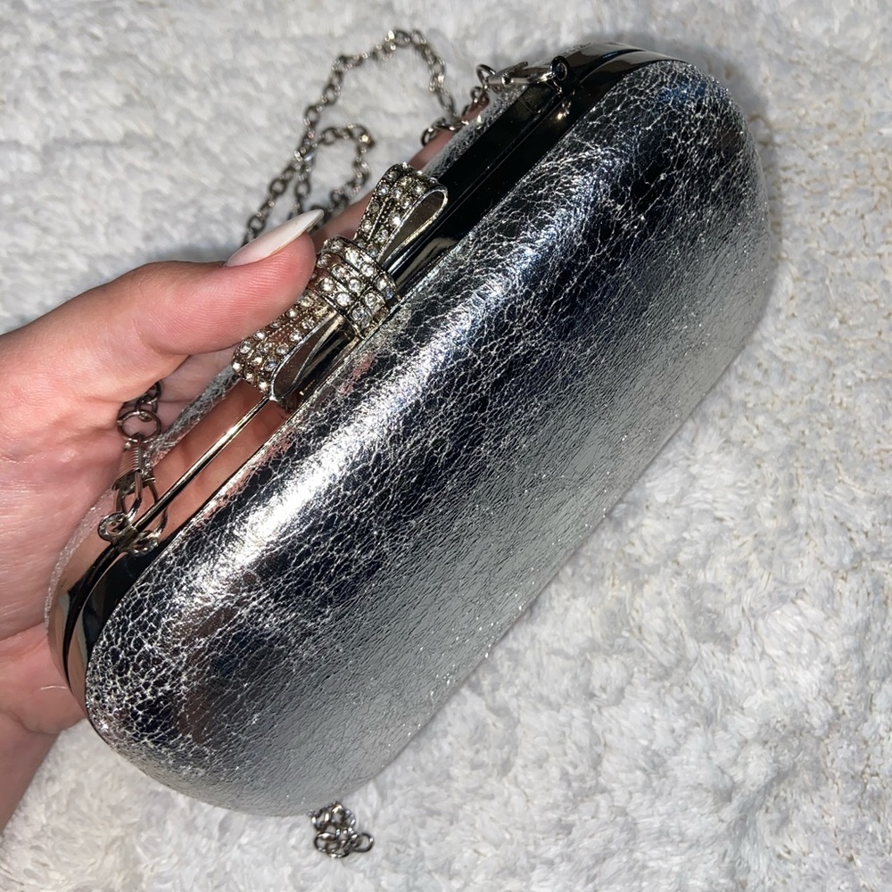 Silver clutch with rhinestone bow snap
